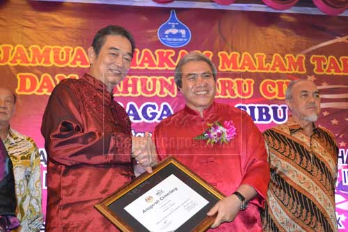 CONGRATULATIONS: Wong (left) receives an award from Awang Tengah in recognition of the 5-star rating of SWB’s website.